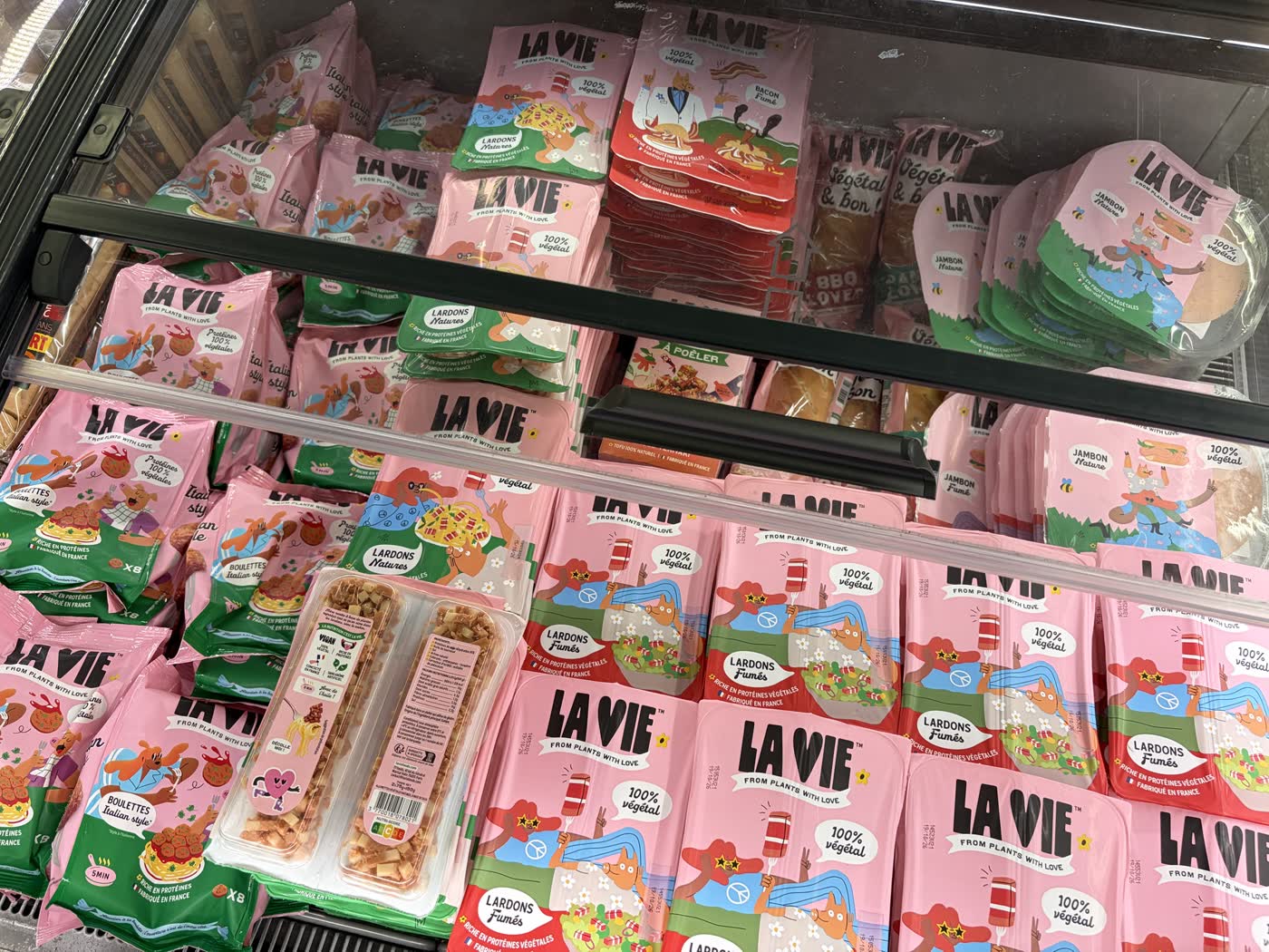 Un rayon frais entier occupé par les produits La Vie : lardons, jambon, bacon, boulettes et sandwichs